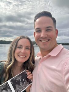 My husband and I holding the sonogram of the baby we lost. Smiling before we lost our baby boy.